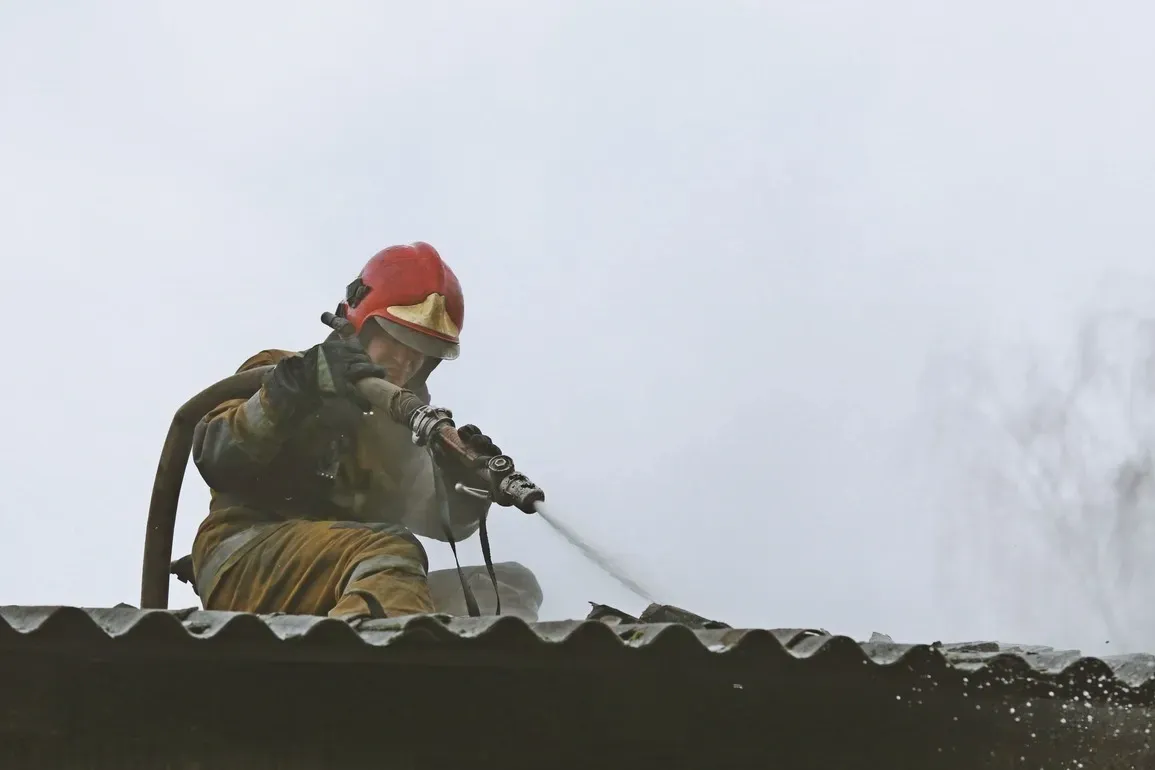 A roof cleaner in full gear, wearing a red helmet, kneels on a corrugated roof and directs a water hose to fix the roof problem.