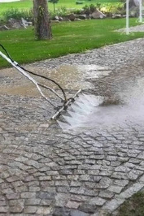 Expert driveway cleaner is cleaning driveway professionally.
